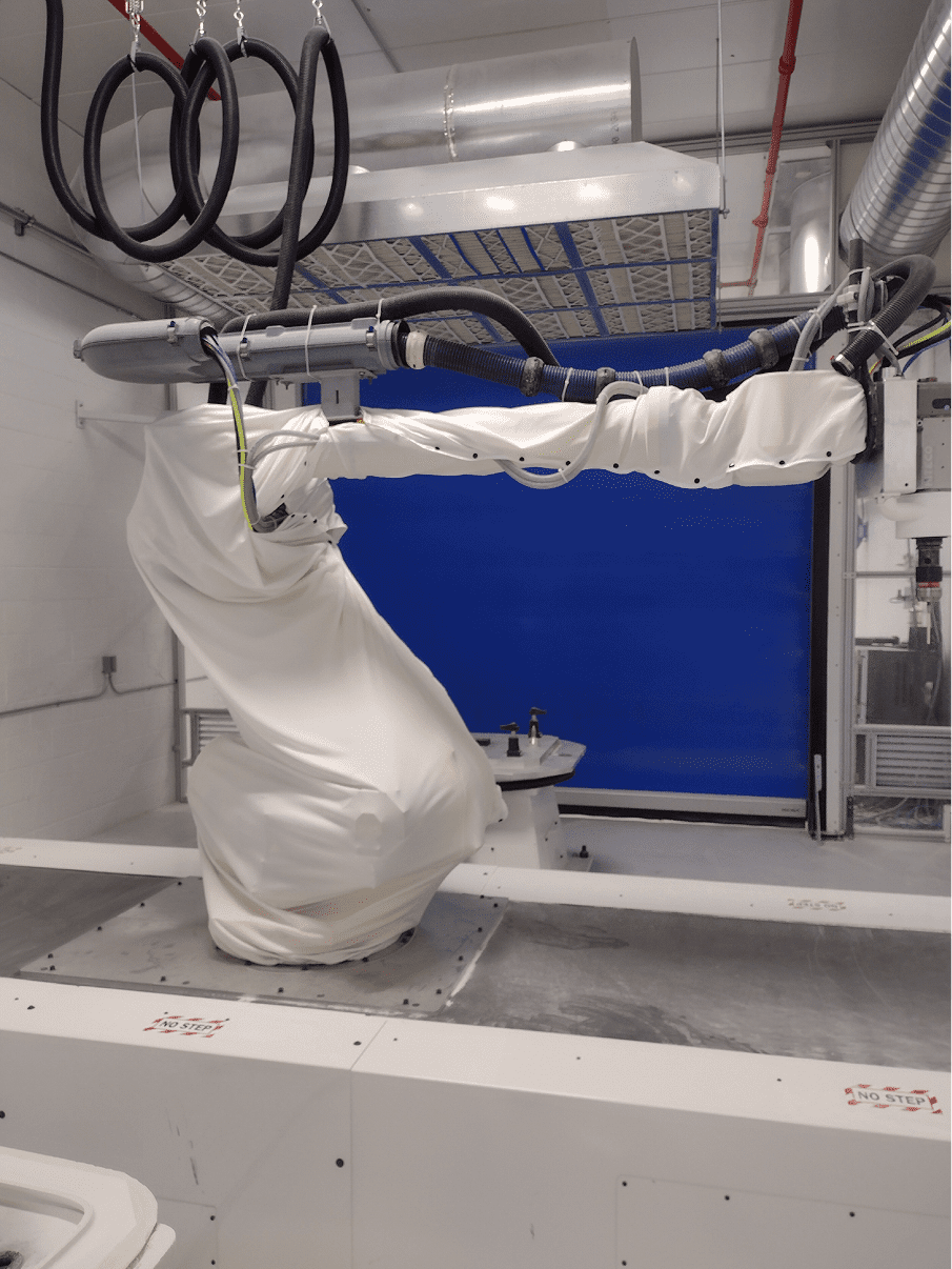 A robotic arm operates inside a clean, controlled environment chamber.