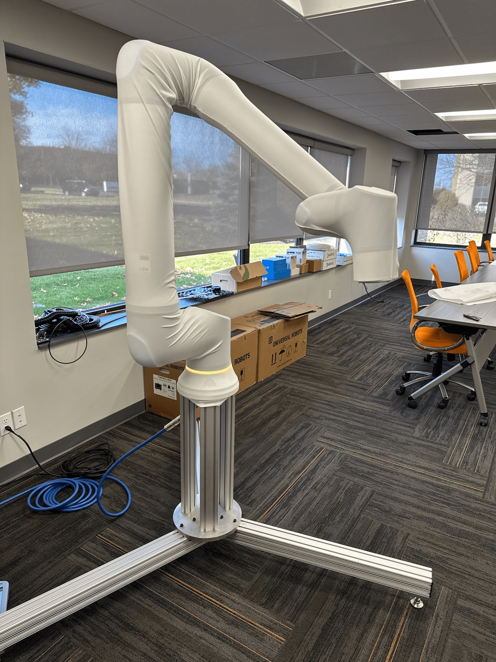 A white adjustable air vent arm in an office space.